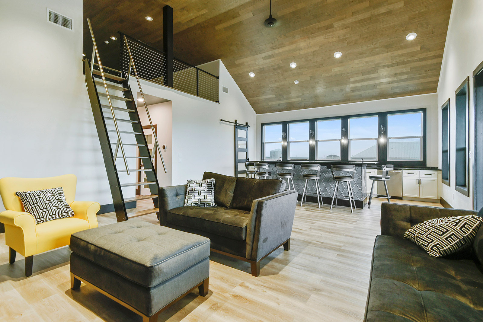 Open-concept kitchen and living area with loft in Borneo House luxury new construction custom home designed and built by DMG