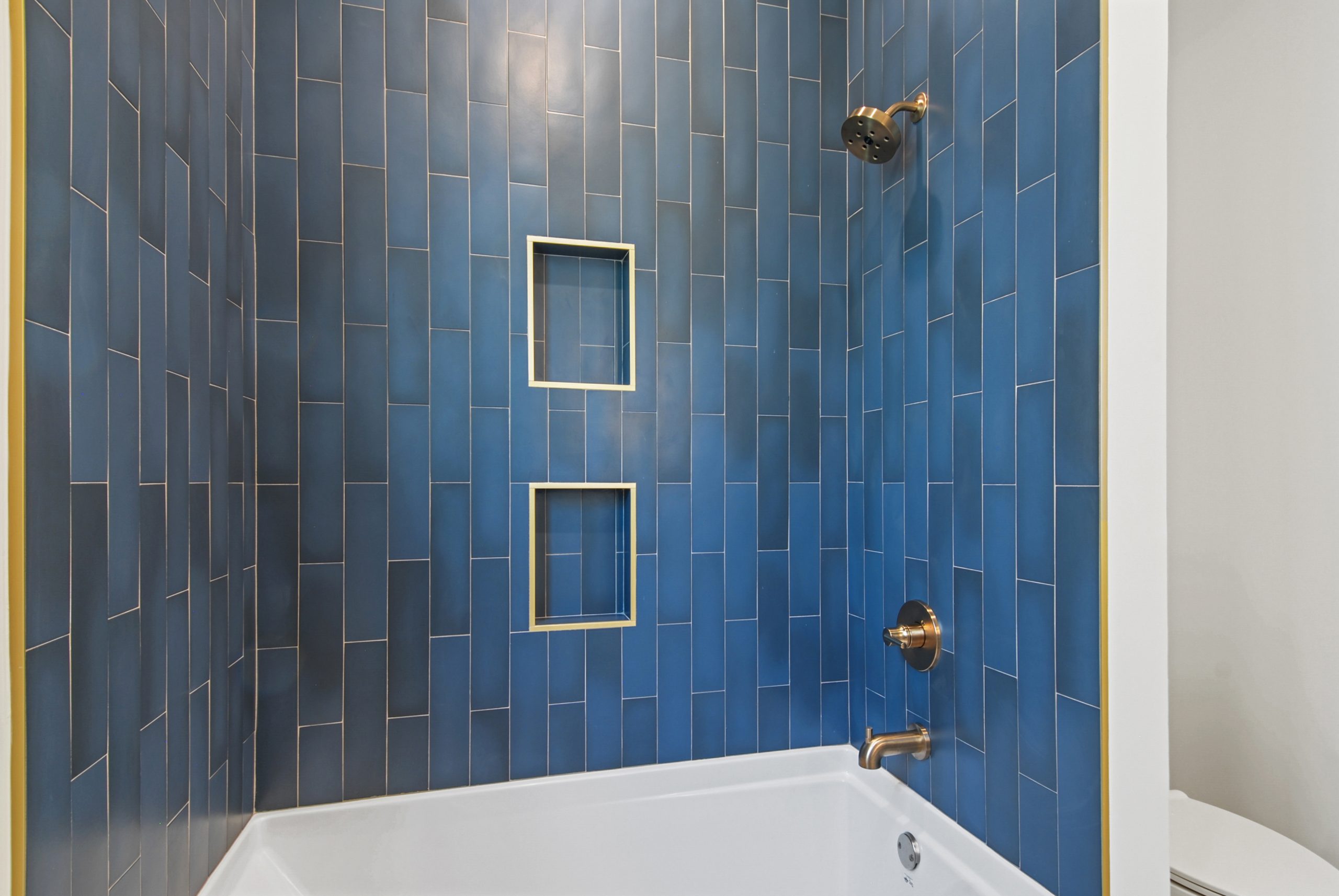 Beautiful blue tiled bathroom in Dogwood House luxury new construction custom home designed and built by DMG