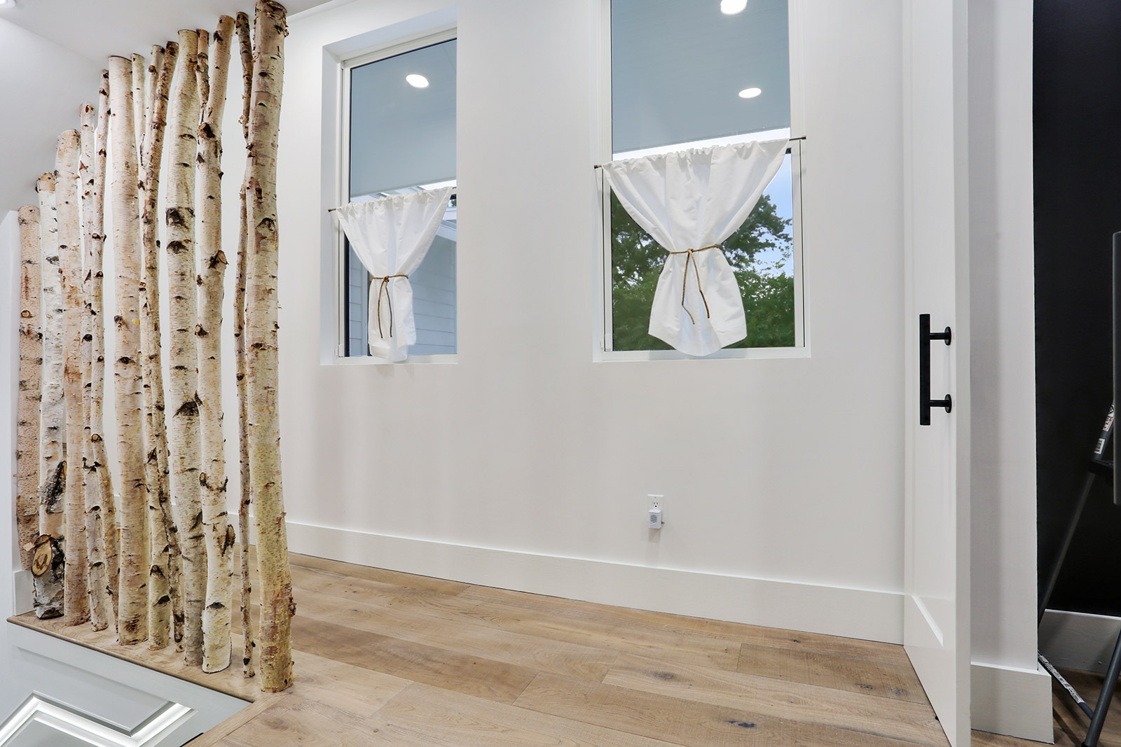 Stairway with custom birch tree railing in Elmeer House luxury new construction home designed and built by DMG Design+Build