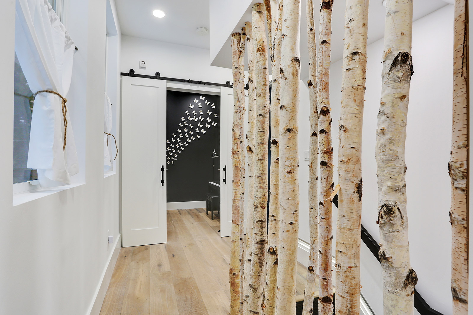 Stairway with custom birch tree railing in Elmeer House luxury new construction home designed and built by DMG Design+Build